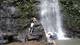 Students take a break under a waterfall in the cloud forest on a hike near the Soltis Center.